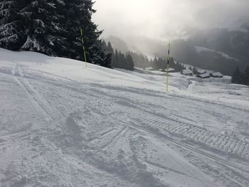 Snow covered land and mountains against sky