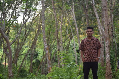 Portrait of young man standing in forest