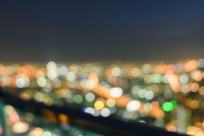 Defocused image of illuminated lights in city at night