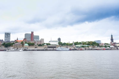 View of city buildings against cloudy sky