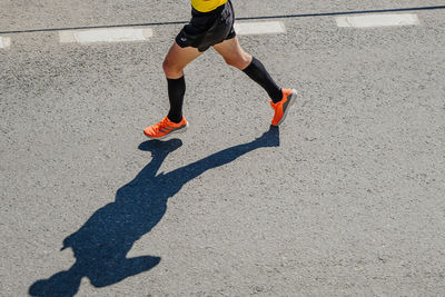 Low section of woman walking on road