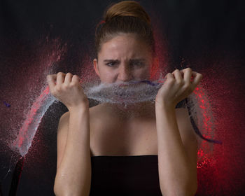 Portrait of woman against black background