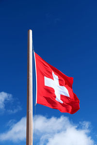 Low angle view of flag against blue sky