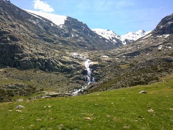 Scenic view of waterfall against sky