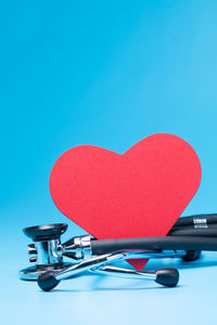 Close-up of heart shape on table against blue background