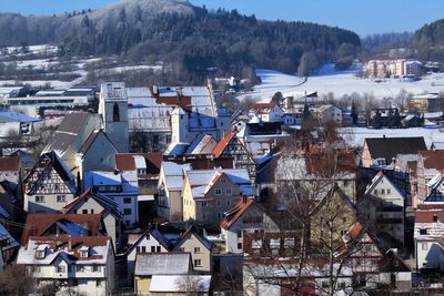 Houses in town against sky during winter