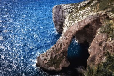 High angle view of rock formations at coastline by sea