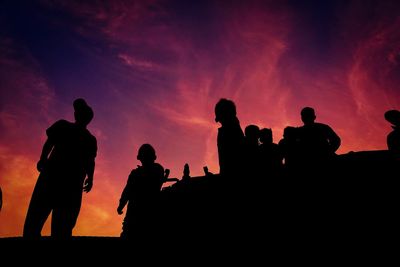 Low angle view of silhouette people against sky at sunset