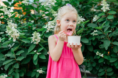 Portrait of cute girl blowing flowers