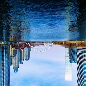 Tilt image of swimming pool by building against sky