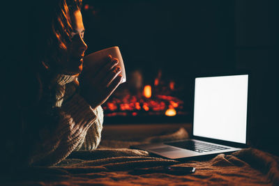 Close-up of woman using laptop on table