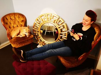 Young woman looking down while sitting on table at home