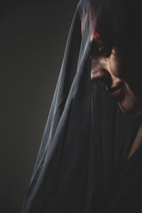 Close-up portrait of young man against black background