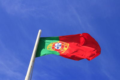 Low angle view of flag against blue sky