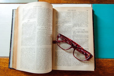 Directly above shot of eyeglasses on open book at table