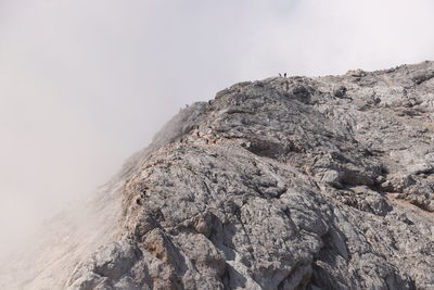 Low angle view of rocky mountain against sky