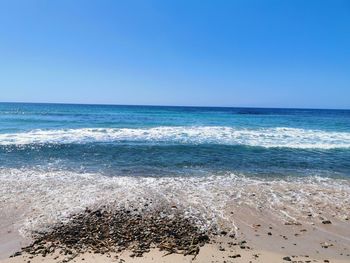 Scenic view of sea against clear blue sky