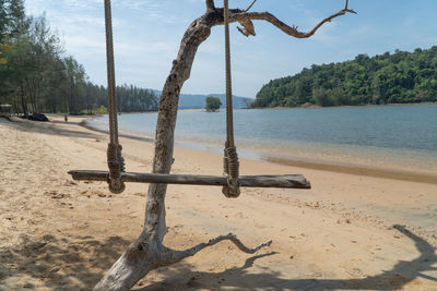 View of swing on beach against sky