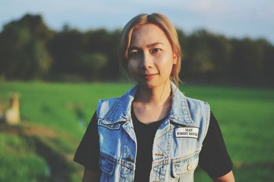 Portrait of young woman standing on field