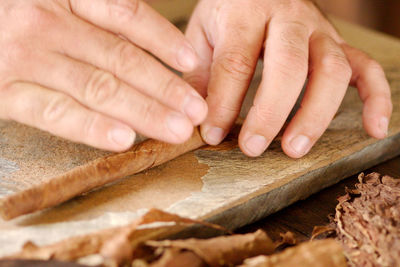 Making cuban cigars by hand in vinales, cuba. close-up of hands and materials.