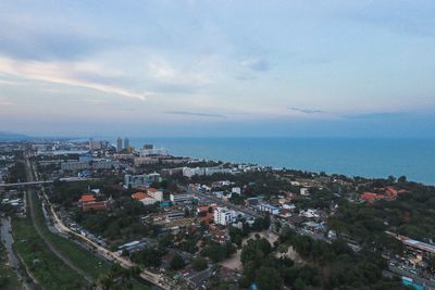 High angle view of townscape by sea against sky