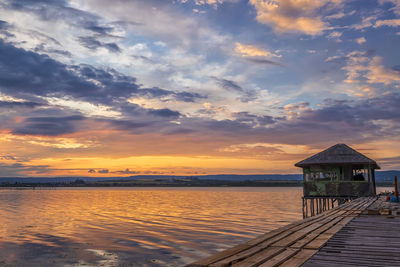 Pier over sea against sky during sunset