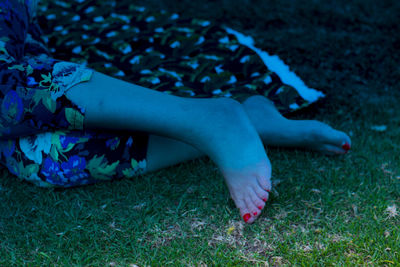 Low section of woman relaxing on grass