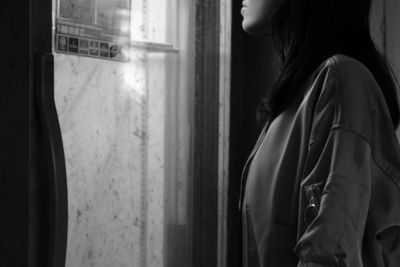 Close-up of woman looking through window