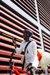 Happy bicycle courier with cell phone and teddy bear