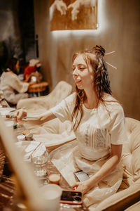 Smiling young woman sitting at home