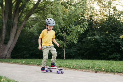 Full length of boy riding skateboard at park