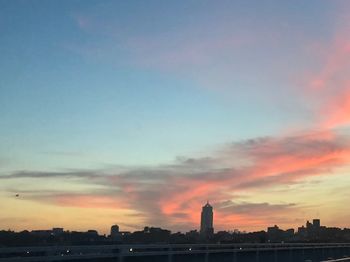 Buildings against cloudy sky during sunset