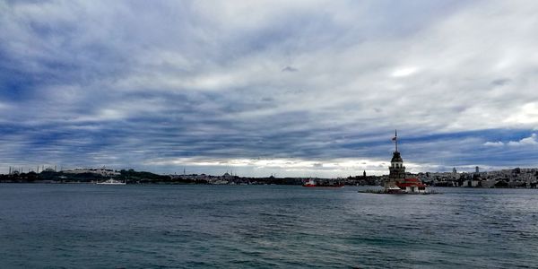 View of buildings in sea against cloudy sky