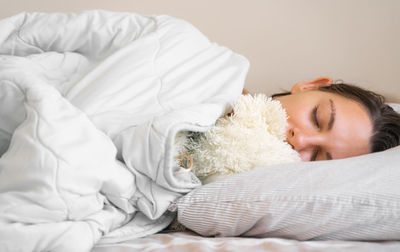 Portrait of woman sleeping on bed