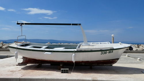 Boats moored on beach against sky 