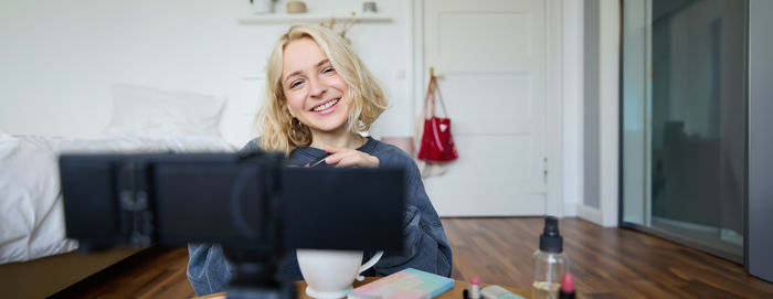 Portrait of young woman sitting at home