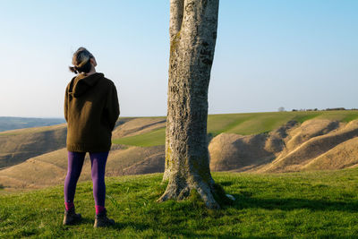 Rear view of woman standing on field