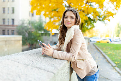 Beautiful woman using smart phone in city
