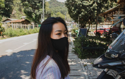 Close-up of beautiful young woman on road in city