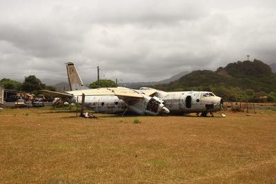 Abandoned airplane on field against sky