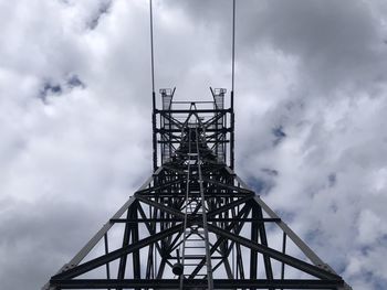 Low angle view of silhouette electricity pylon against sky