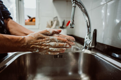 Midsection of man in kitchen at home