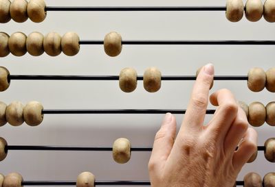 Cropped hand touching abacus