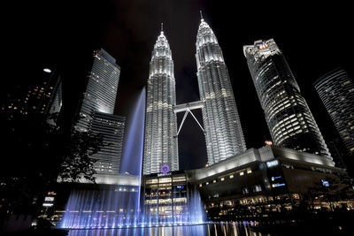 Low angle view of illuminated buildings against sky at night