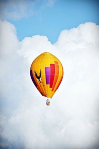 Multi colored hot air balloon flying against sky
