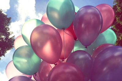 Close-up of bunch of balloons against cloudy sky