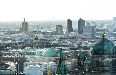 Aerial view of buildings in city against clear sky