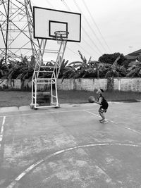 Boy playing with basketball on sports court