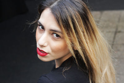 Close-up portrait of beautiful young woman standing on footpath