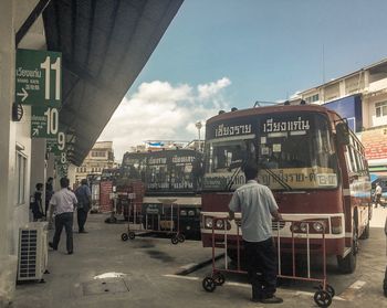 People walking on street in city against sky